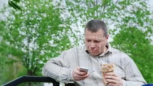 公园里的人吃垃圾食品，用你的智能手机视频