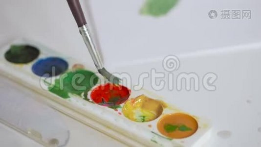 一个小孩子用水彩画，用颜料把手指弄湿视频