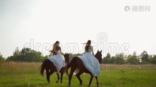 两个穿着白色连衣裙的女孩骑马。 女孩们骑马在田野上跳跃。 慢动作。视频