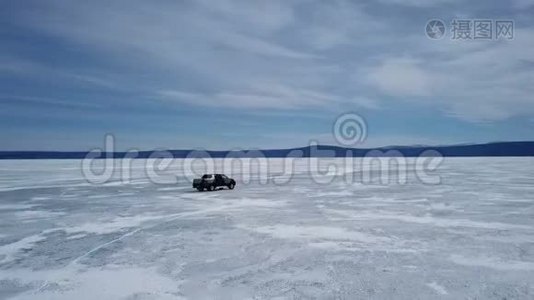 在冬季景观中驾驶汽车的无人机空中景观和高速驾驶过冰冻的湖泊。视频