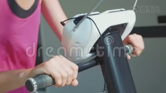 运动缓慢的年轻女子在健身馆骑自行车的画像视频