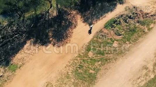男子骑自行车在尘土飞扬的轨道上，俯视。视频