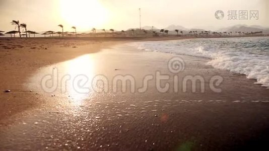 日落时海浪在金色沙滩上翻滚的极端慢动作视频视频