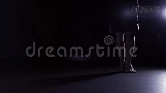 男人的腿在黑暗的健身房里跳绳，慢点视频