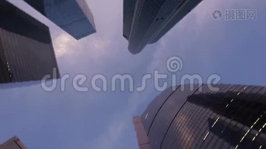 用玻璃制成的现代化摩天大楼前旋转的低角度镜头视频