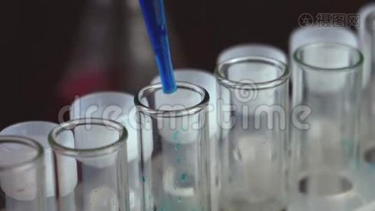 在一个实验室里，一位拿着吸管的科学家分析了一种蓝色液体来提取试管中的DNA和分子。 医生工作视频