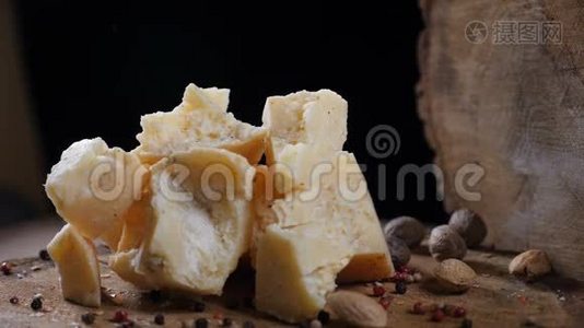 木制背景上的各种奶酪。 坚果和香料在缓慢运动中下降。 食品艺术。 开放式厨房厨师视频