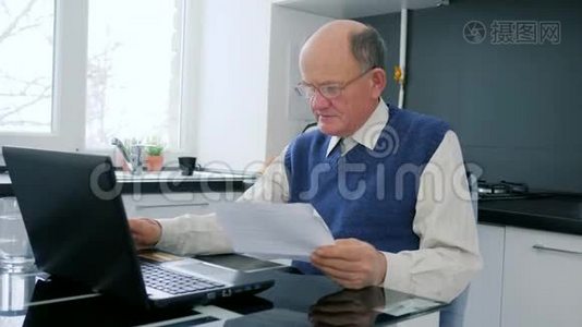网上购物养老金领取者在电脑上工作，在家庭办公室有文件视频