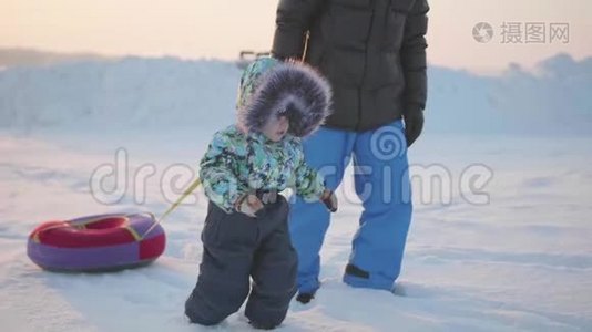 快乐的孩子和他的父亲一起经历雪。 多雪的冬季景观。 户外运动视频