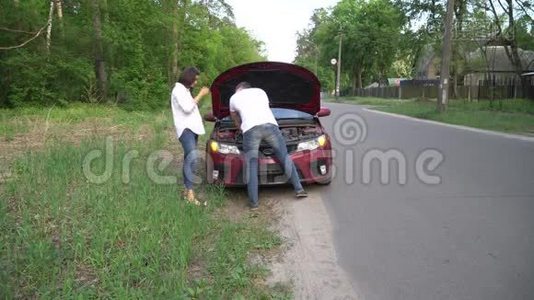 男人正在农村的中央帮那个女人拿她的破车。视频