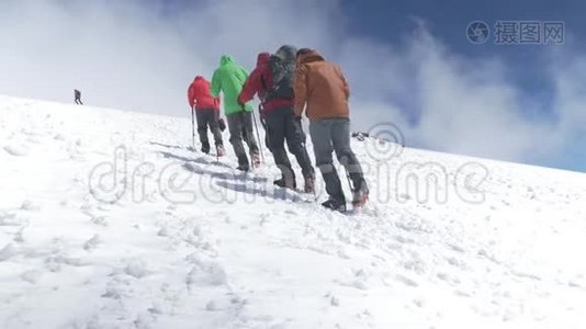 登山者登上雪坡的山顶. 在晴朗的天气里。 高加索山脉慢运动视频