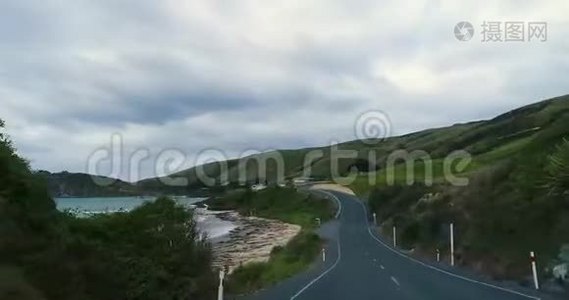 沿着蜿蜒的道路旅行，穿过靠近海岸的山丘，带着岩石。视频