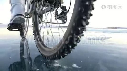 轮胎的视图。 拍摄180fps.. 女人在冰上骑自行车。 冰的贝加尔湖。 上面的轮胎视频