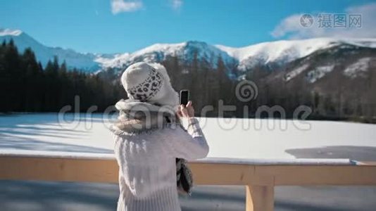 女士冬季用智能手机与太阳激光拍照视频