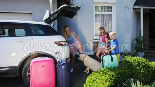 女人和她的孩子正在叫他们的狗上车，然后把行李装上车视频