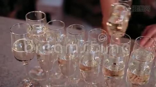 酒保准备的一张桌子上放着香槟酒杯，准备香槟酒。视频