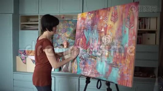 女艺术家在艺术工作室画一幅手的抽象画。 侧视。 4千克视频