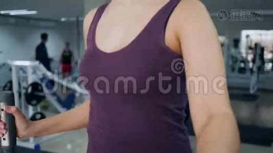 在健身室，女运动员在椭圆机上做有氧运动视频