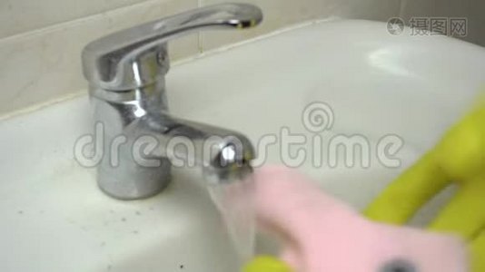手里拿着黄色的橡胶手套，用抹布用清洁剂清洗浴室水槽视频