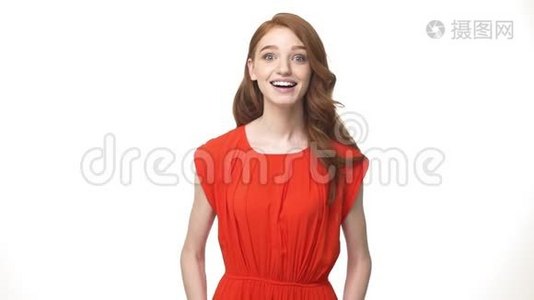 快乐的年轻白种人红头发的女孩站着，兴奋地说是的，孤立在白色的背景上。视频