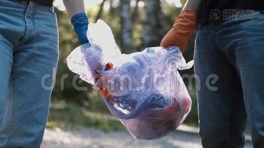 两名志愿者在清理森林后拿出垃圾和回收塑料瓶视频
