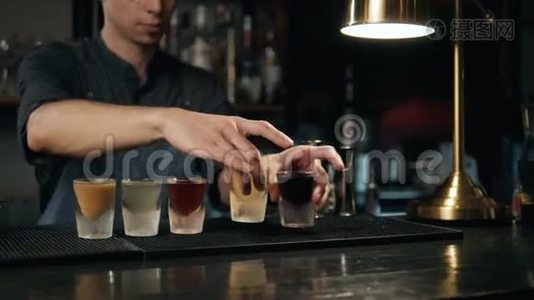 一排漂亮的不同颜色的鸡尾酒酒酒调酒师在聚会上，马提尼，伏特加和其他装饰。视频