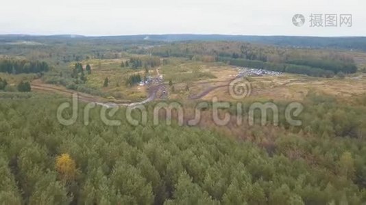 森林附近潮湿肮脏的乡村道路，有汽车和卡车。 剪辑。 空中景观视频