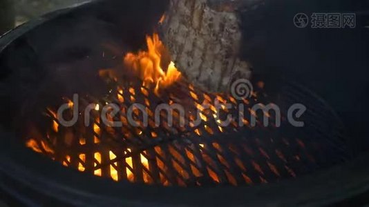 烧烤，厨师用铁钳把一块多汁的牛肉或羊肉翻过来，火在燃烧，冒烟视频