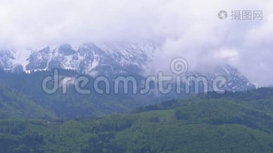 云层和森林中白雪覆盖的山峰的全景视频