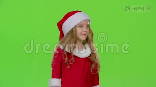 穿着红色西装的圣诞老人助手正站在房间里眨眼。 绿色屏幕视频