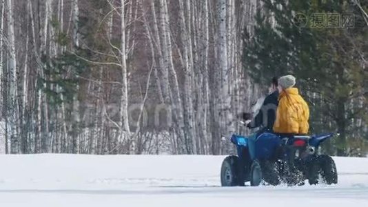 人们穿着明亮的冬天的衣服在森林里骑着雪地摩托视频