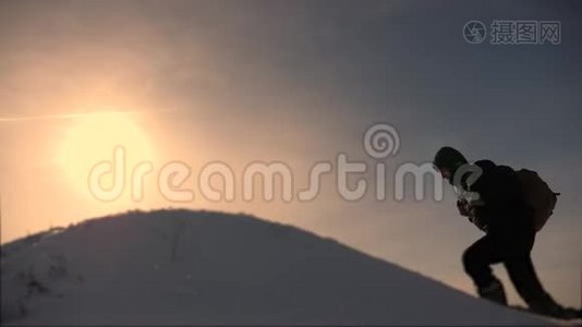 商务人员的团队合作。 三个登山者在一座白雪覆盖的小山上一个接一个地爬。 商务人员团队视频