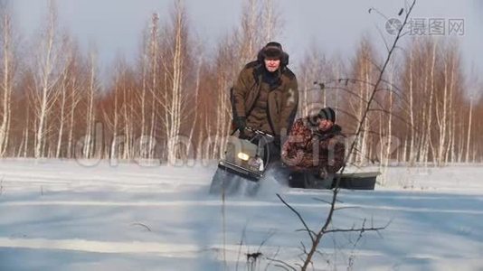 穿冬装的成年男子在小型雪地车拖车上快速骑行载客视频