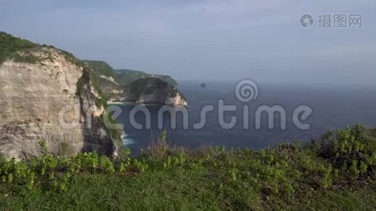 年轻女子张开双臂，站在岩石上，望着大海视频