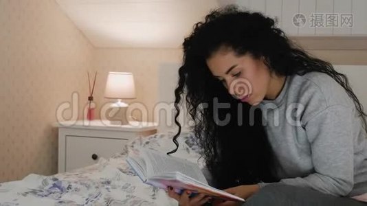 年轻漂亮的卷发黑发，在床上看书视频