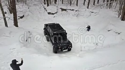 越野车要从深坑里骑出来，在白雪覆盖的道路上冬天的森林。 非公路视频