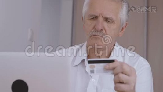 老人在家里用笔记本电脑上网，打信用卡号码视频