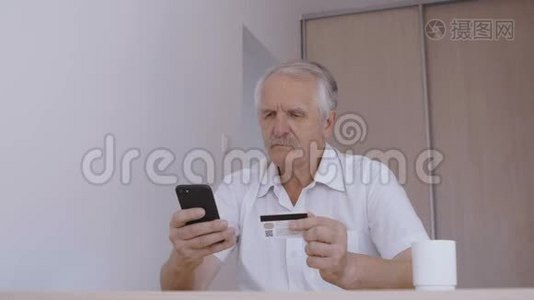 老人在家用智能手机用信用卡在线购物。 网上银行手机应用视频