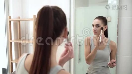 化妆。 女人用粉末照镜子视频