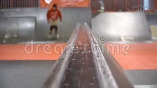 一个穿着橙色运动衫的人在溜冰场里用溜冰鞋溜冰，动作很慢。 Nifft视频