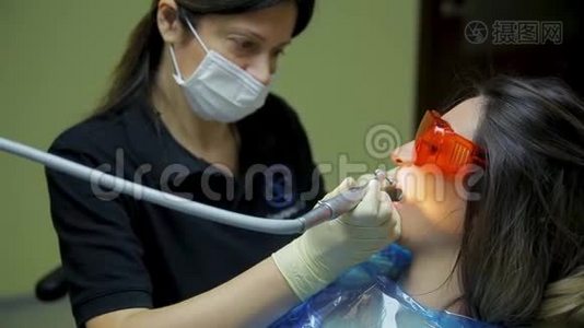 在医疗牙科诊所为年轻女性患者提供近距离的女医生口腔医生治疗和美白牙齿视频