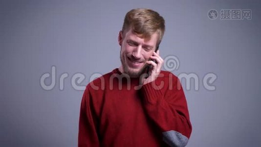 特写照片：一个迷人的白种人，他在电话中交谈，在镜头前微笑视频