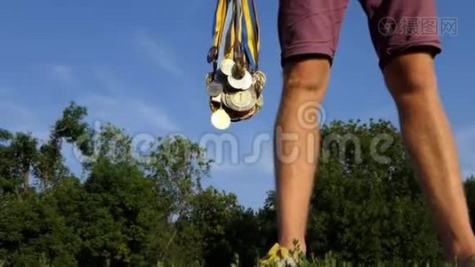 夏天，年轻人在湖岸上举起一捆奖章视频