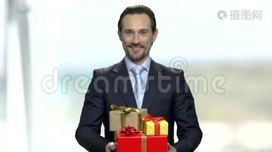 微笑的商人拿着礼品盒。视频