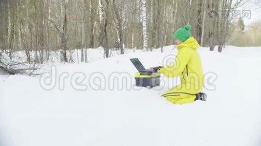 在冬季森林里的笔记本电脑上工作的运动服装生态学家视频