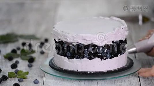 厨房里的糖果师用浆果奶油做一个海绵蛋糕。 自制糕点，烹饪糕点的概念.. 系列。视频