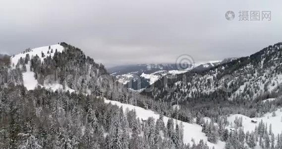 从空中飞向白雪皑皑的森林和山丘。 多云坏阴多雾天气.. 意大利阿尔卑斯山冬季白云石视频