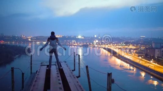 自由，男人举起双手站在桥上，欣赏城市令人惊叹的夜景视频