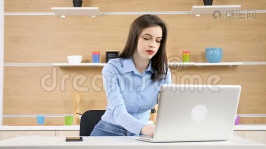 女商人在家工作。 她正在厨房里用笔记本电脑打字视频