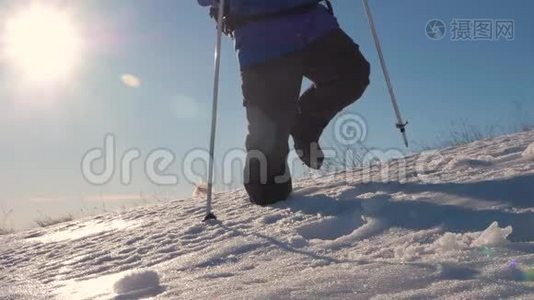 徒步旅行者在冬天寒冷的雪天徒步旅行。 在山脉的背景下，腿沿着山脊走视频